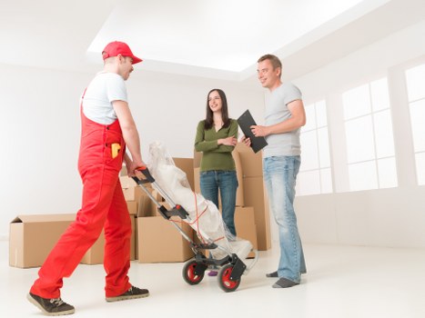 Removal team loading packed boxes and furniture for a house move