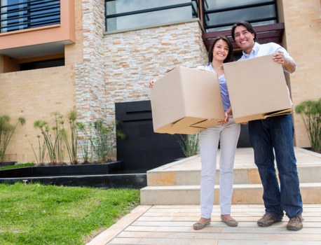 Movers using protective equipment while carrying furniture during a safe relocation